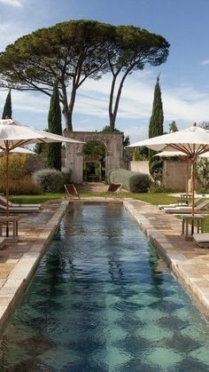 an outdoor swimming pool with umbrellas and chairs