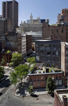 an aerial view of a city with tall buildings and lots of trees in the foreground