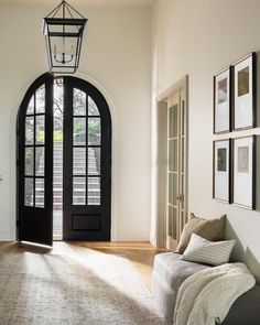 a living room with an arched door and rug