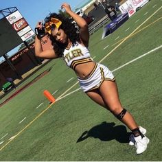 a cheerleader is standing on the football field