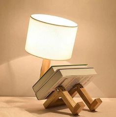 a lamp that is sitting on top of a wooden stand next to an open book