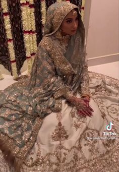 a woman sitting on top of a bed in a wedding dress