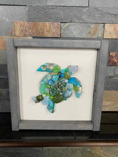 a sea turtle made out of glass in a frame