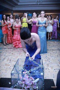 a woman in a blue dress is chained to a glass box with chains on it