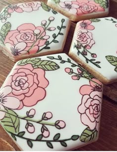 four decorated cookies sitting on top of a wooden table