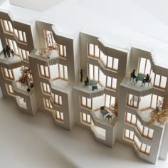 an architectural model of a building with several windows and people walking around the outside area