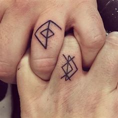 two people with matching tattoos on their fingers