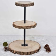 three tiered tree slice cake stand with pine cones