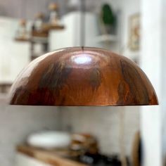 a wooden light hanging from the ceiling in a kitchen