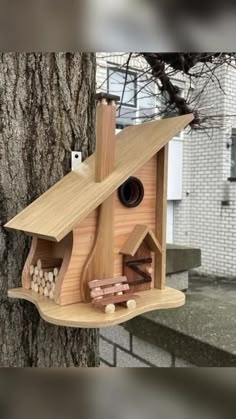 a wooden bird house on the side of a tree