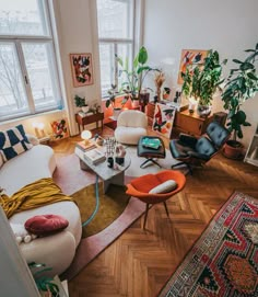 a living room filled with lots of furniture and plants on top of windowsills