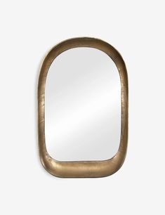 an oval mirror with a gold frame