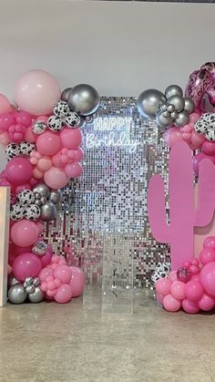 balloons and streamers decorate the entrance to a birthday party with pink, silver and white decorations