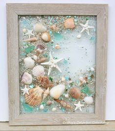 a frame with shells and sea glass in it