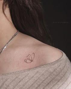 a woman with a small heart tattoo on her chest