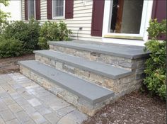 some steps leading up to a house with red shutters