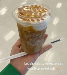 a hand holding a starbucks iced vanilla latte with sweet cream