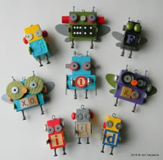 six colorful robot ornaments sitting on top of a table