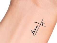 the word hope written in cursive writing on a woman's wrist tattoo