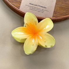 a yellow flower sitting on top of a table