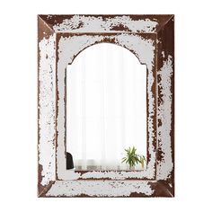 a mirror that is sitting on top of a table next to a potted plant