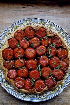 a pie with tomatoes and herbs on top