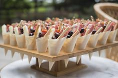 small appetizers are lined up on a wooden platter, ready to be eaten