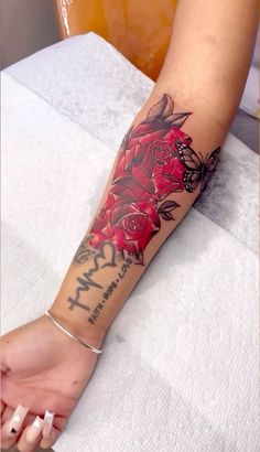 a woman's arm with red roses on it and the words my mom written in black ink