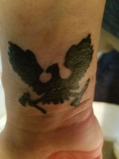 a person with a tattoo on their wrist that has a bird on it's arm