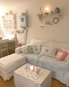 a living room filled with lots of furniture next to a white table and wall mounted shelves