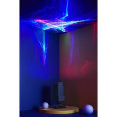 a room with blue, red and purple lights on the ceiling above it is a speaker