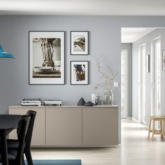 a dining room table with chairs and pictures on the wall above it, along with other furniture