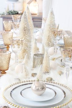 a christmas table setting with white and gold decorations