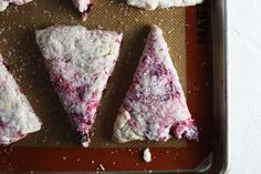 four pieces of pizza sitting on top of a baking sheet covered in powdered sugar