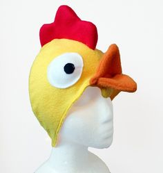 a white mannequin head with a yellow chicken hat on it's head