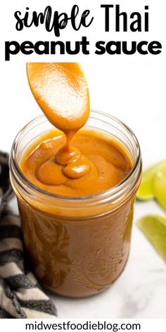 a spoon full of caramel sauce being poured into a jar