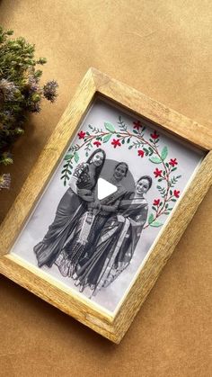 a wooden frame with an image of two women on it and flowers in the background