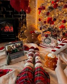 a person laying in front of a christmas tree with their feet up on the floor