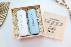 two personalized blue and white bottles in a wooden box next to a tassel