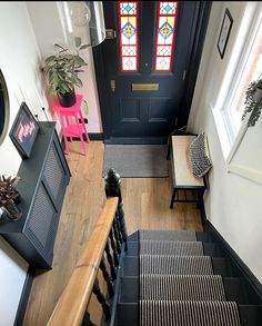 an overhead view of a stair case and stained glass window in a home with wood floors