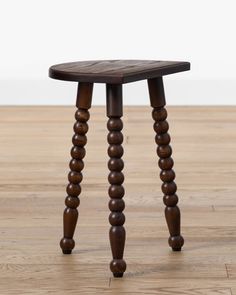 a small wooden stool sitting on top of a hard wood floor