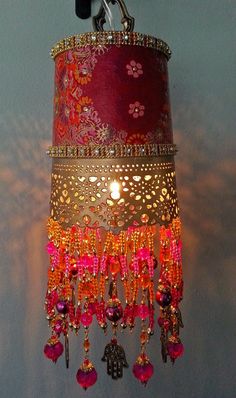 a chandelier hanging from the ceiling with pink and orange beaded decorations on it