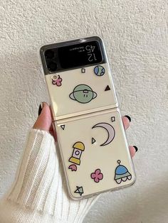 a person holding up a phone case with stickers on it's back and sides