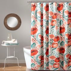 a bathroom with a bathtub, mirror and shower curtain in orange and blue flowers