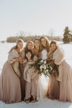 a group of women standing next to each other on top of a snow covered field