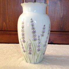 a white vase with lavender flowers painted on it