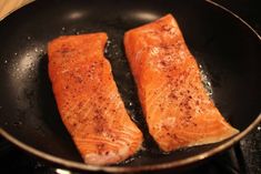 two salmons cooking in a frying pan on the stove