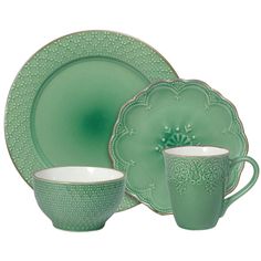 a green dinner set with two cups and saucers on the side, one has an ornate design