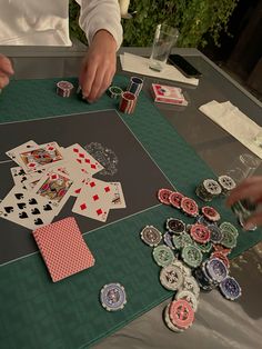 two people are playing cards on a table