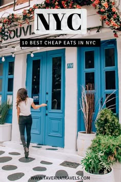 a woman walking into a restaurant with blue doors and flowers on the front door, in new york city